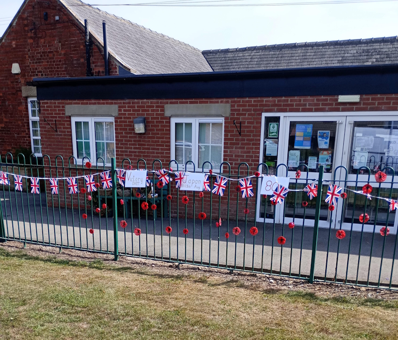 VJ Day 80th Anniversary, close up of flags on the school railings